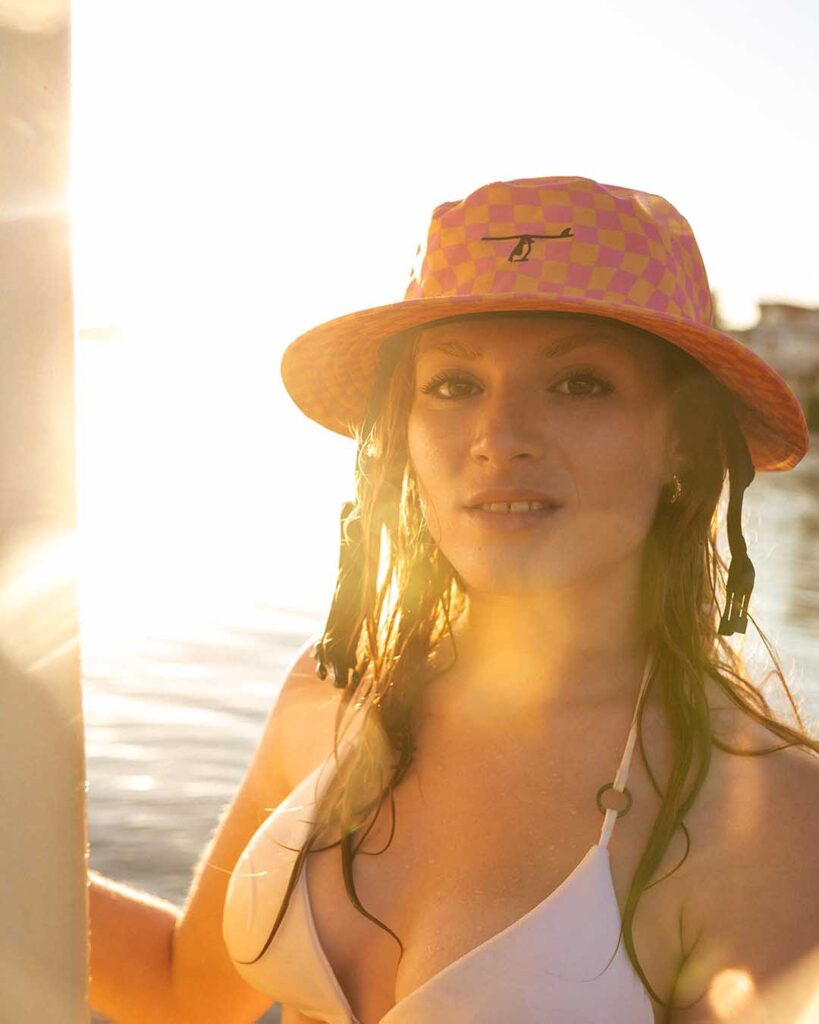 Fotografía estilo de vida en Murcia: grupo de amigos disfrutando del mar con sombreros coloridos. Imagen natural y espontánea para marcas que transmiten alegría, aventura y estilo de vida al aire libre