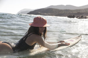 Fotografía estilo de vida en Murcia: grupo de amigos disfrutando del mar con sombreros coloridos. Imagen natural y espontánea para marcas que transmiten alegría, aventura y estilo de vida al aire libre